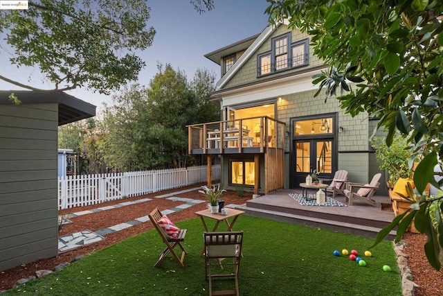 rear view of house featuring a patio, a deck, and a lawn