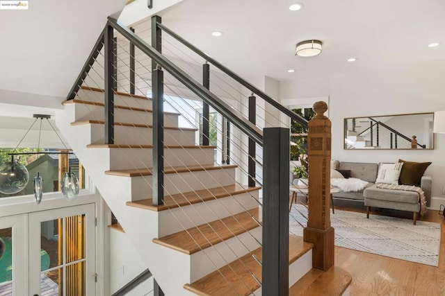 stairs featuring wood-type flooring and plenty of natural light