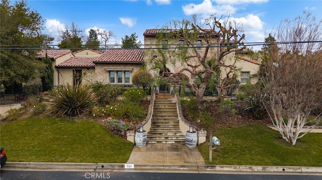 mediterranean / spanish-style home with a front yard