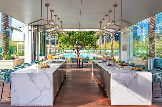 view of patio featuring a sink, outdoor dining area, and a pool