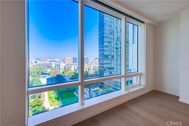 room details featuring baseboards, a view of city, and wood finished floors