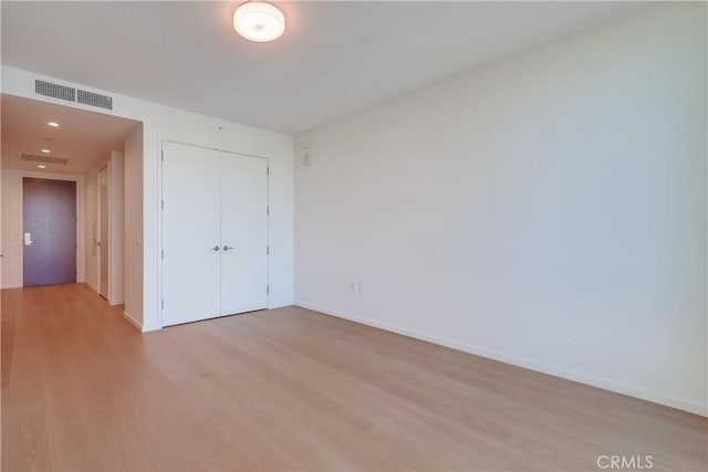 unfurnished bedroom with visible vents, baseboards, light wood-type flooring, recessed lighting, and a closet