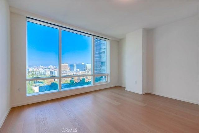 unfurnished room with a healthy amount of sunlight and light hardwood / wood-style flooring