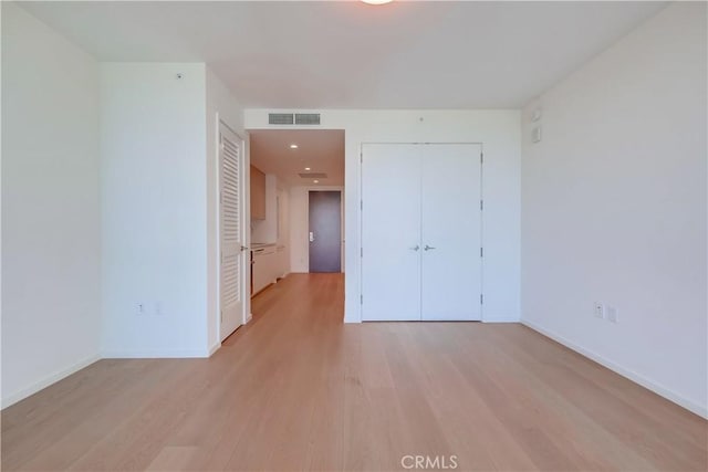 unfurnished bedroom with baseboards, visible vents, and light wood finished floors