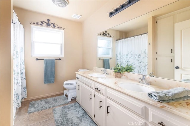 bathroom featuring vanity, a healthy amount of sunlight, and toilet