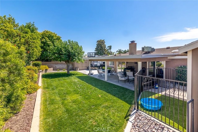 view of yard with a trampoline, central AC unit, and a patio area