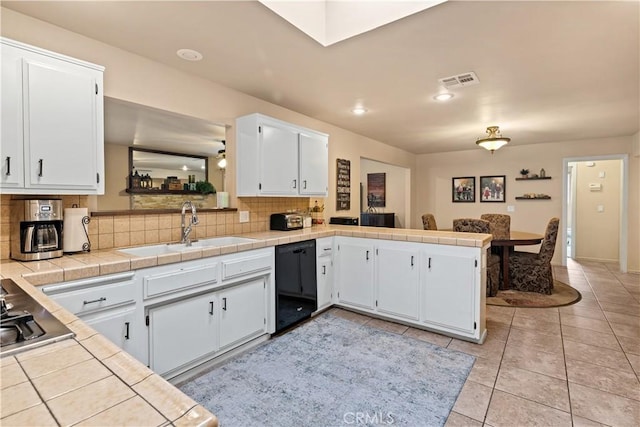 kitchen with tile countertops, white cabinetry, dishwasher, sink, and kitchen peninsula