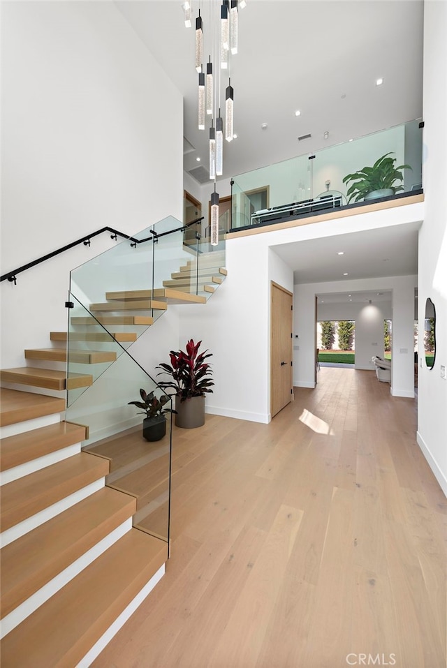 staircase featuring hardwood / wood-style floors and a high ceiling