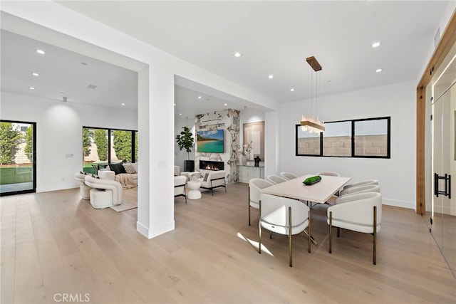 dining area featuring a fireplace and light hardwood / wood-style floors