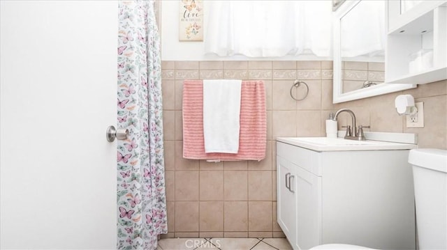 bathroom featuring tile walls, vanity, curtained shower, and toilet