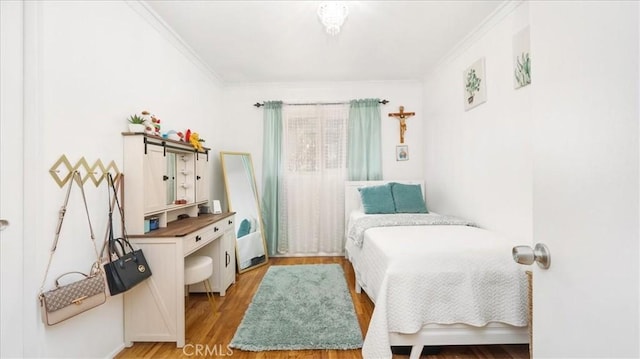 bedroom with light wood-style flooring and crown molding