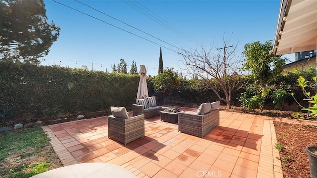 view of patio with a fenced backyard and an outdoor living space with a fire pit