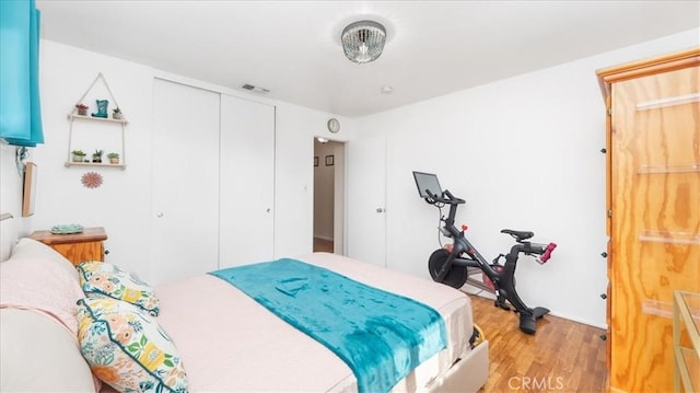 bedroom featuring a closet, wood finished floors, and visible vents