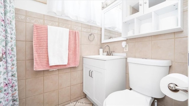 full bath featuring a shower with curtain, tile walls, toilet, and vanity