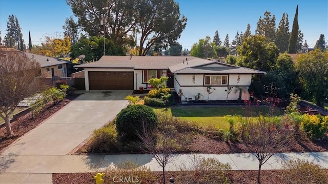 ranch-style house featuring an attached garage, driveway, and a front lawn