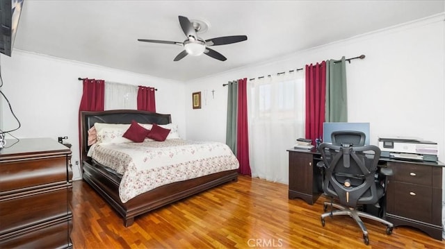 bedroom with crown molding, ceiling fan, and wood finished floors