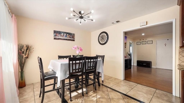 dining space featuring light tile patterned flooring, a notable chandelier, and visible vents