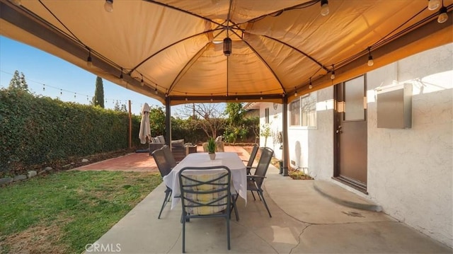 view of patio / terrace with outdoor dining space, fence, and a gazebo