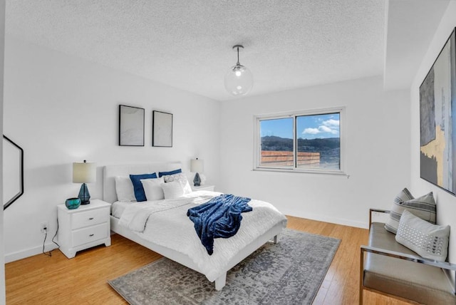 bedroom with wood-type flooring and a textured ceiling