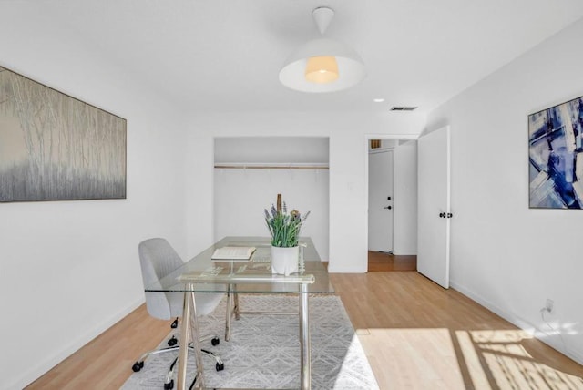 home office with light hardwood / wood-style flooring