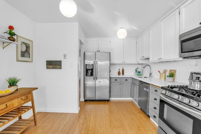 kitchen with sink, decorative backsplash, stainless steel appliances, and white cabinets