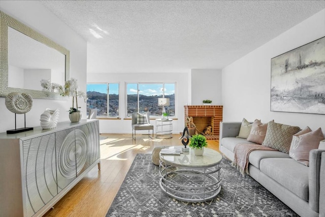 living room featuring a brick fireplace, hardwood / wood-style floors, and a textured ceiling