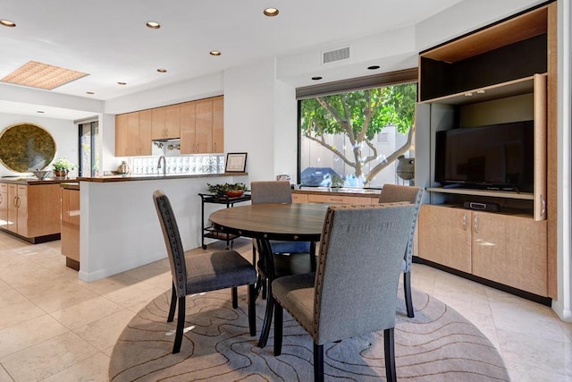 tiled dining room featuring sink