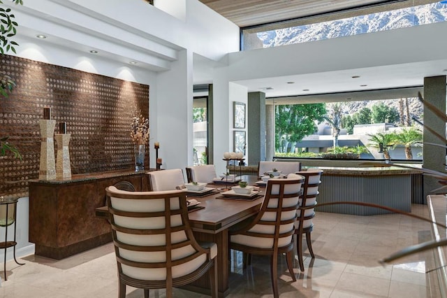 tiled dining room featuring a towering ceiling and a wealth of natural light