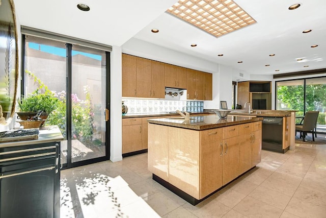 kitchen featuring black dishwasher, a kitchen island with sink, and light tile patterned floors