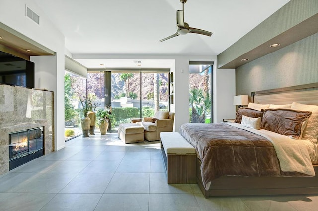 bedroom featuring access to exterior, vaulted ceiling, light tile patterned floors, ceiling fan, and a premium fireplace