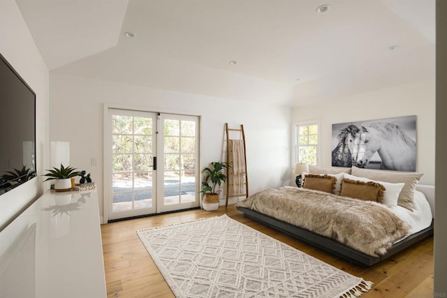 bedroom with lofted ceiling, access to outside, and light hardwood / wood-style flooring