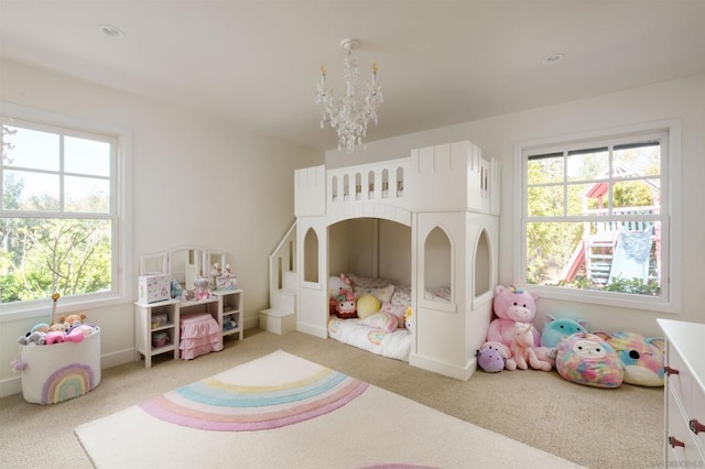 carpeted bedroom featuring an inviting chandelier