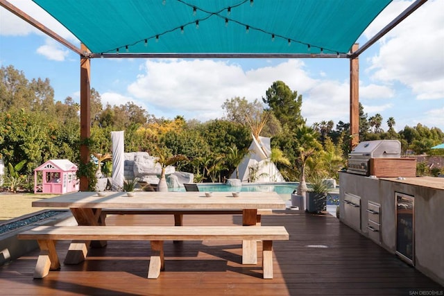 wooden terrace with area for grilling, wine cooler, and grilling area