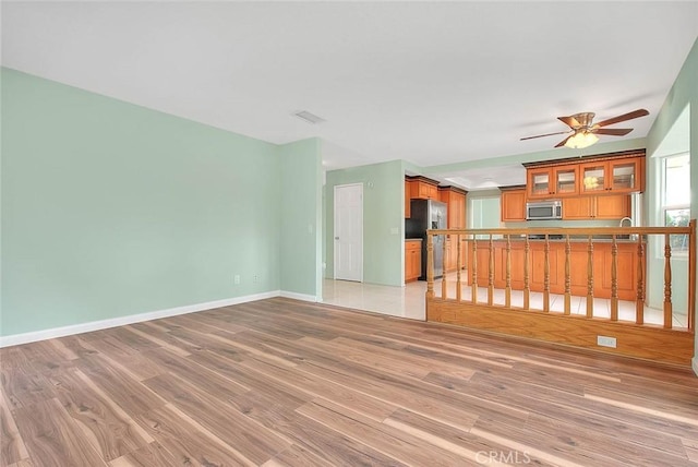 unfurnished living room with ceiling fan and light hardwood / wood-style floors