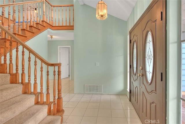 foyer with light tile patterned floors and high vaulted ceiling