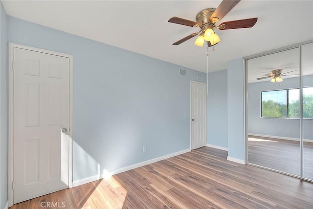 unfurnished bedroom with hardwood / wood-style floors, ceiling fan, and a closet