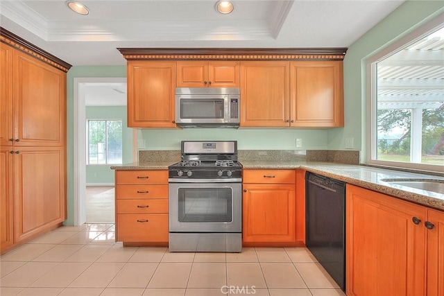 kitchen with light stone counters, light tile patterned floors, stainless steel appliances, and a raised ceiling