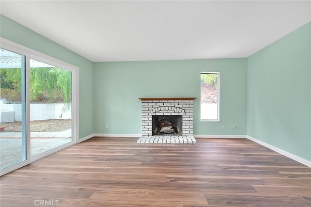 unfurnished living room featuring wood-type flooring and a fireplace