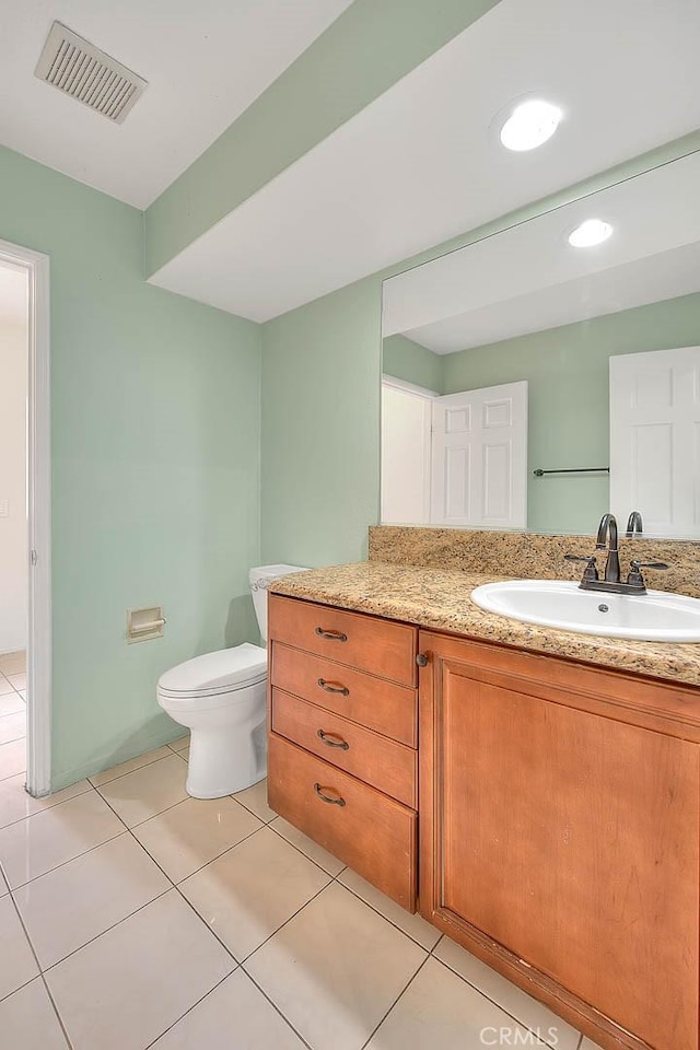 bathroom featuring vanity, tile patterned floors, and toilet