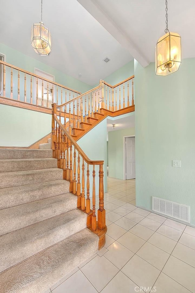 staircase featuring tile patterned flooring and beamed ceiling