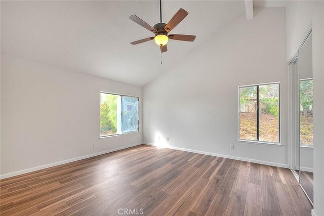 empty room featuring beamed ceiling, ceiling fan, high vaulted ceiling, and hardwood / wood-style floors