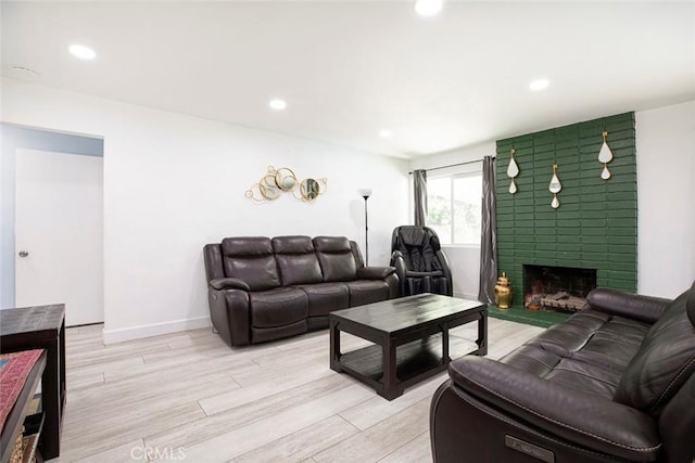 living room with a fireplace and light wood-type flooring