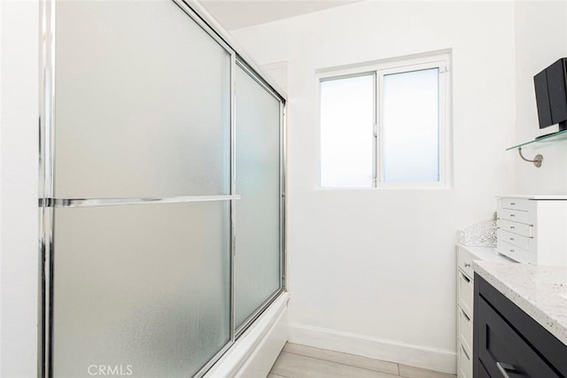 bathroom featuring vanity and bath / shower combo with glass door