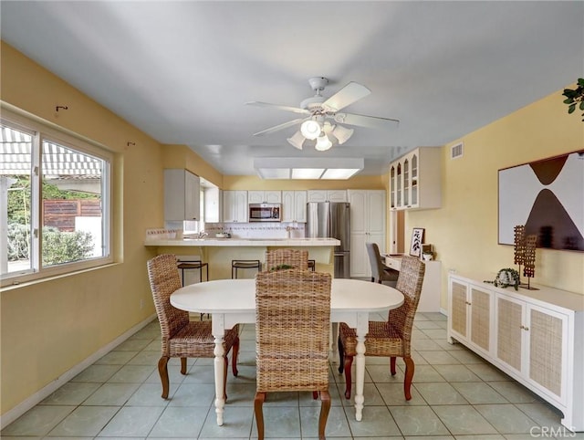 dining area featuring ceiling fan and light tile patterned flooring