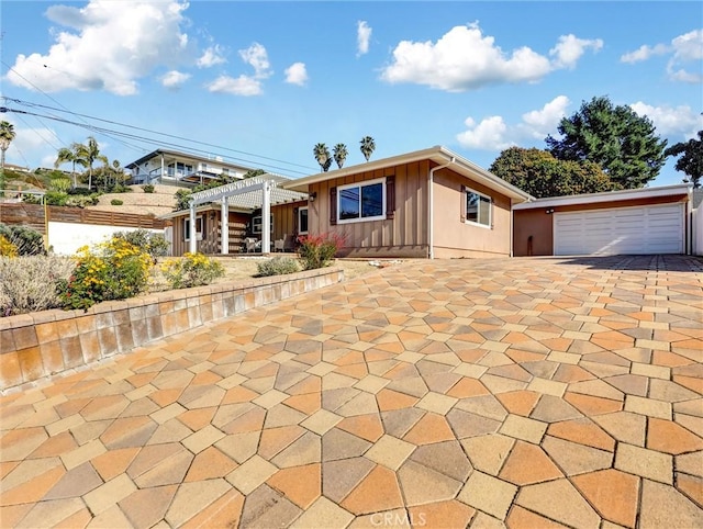 view of front of property featuring a garage and a pergola