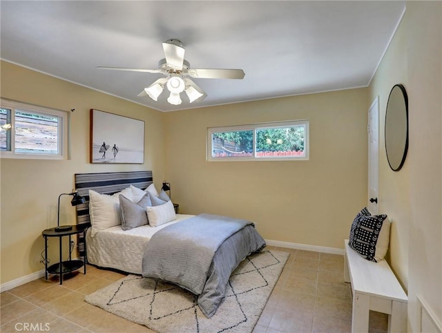 bedroom featuring multiple windows, light tile patterned floors, and ceiling fan