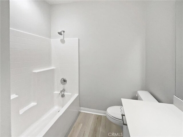 full bathroom with vanity, hardwood / wood-style floors, shower / bathtub combination, and toilet