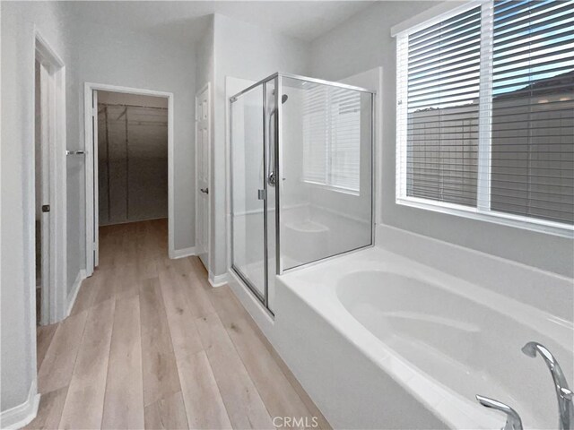 bathroom featuring hardwood / wood-style floors and separate shower and tub