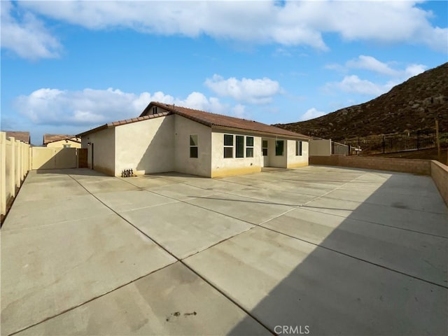 5393 Viewstone Ct, Hemet, CA 92545 - back of house with a fenced backyard, stucco siding, a mountain view, a patio area, and a tiled roof