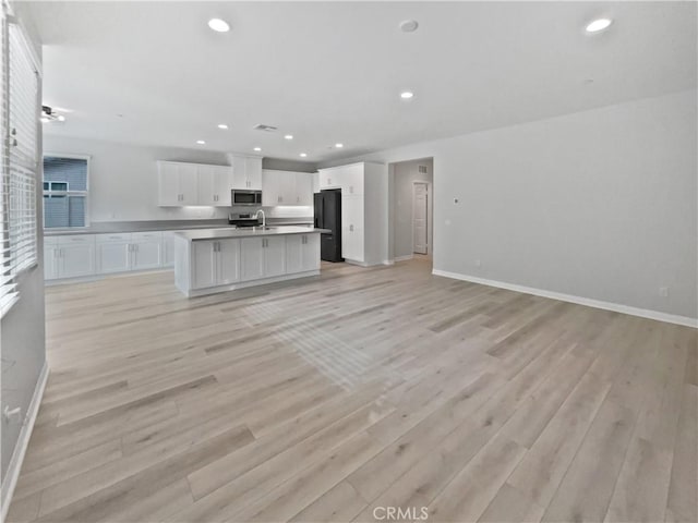 5393 Viewstone Ct, Hemet, CA 92545 - unfurnished living room with light wood finished floors, baseboards, recessed lighting, and a sink